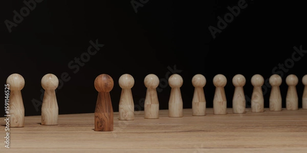 Fototapeta One dark wooden figure standing out among identical light wood figures on a desk. Concept of leadership, uniqueness, diversity, social identity, and inclusion.