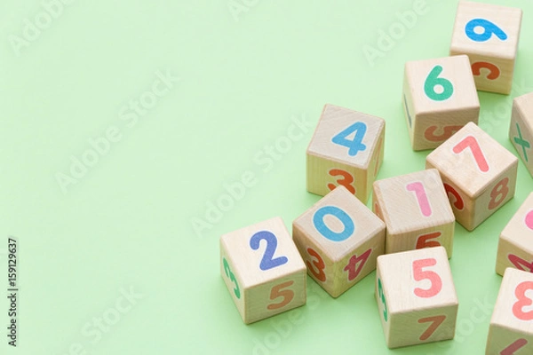 Fototapeta Wooden cubes with numbers on light green background
