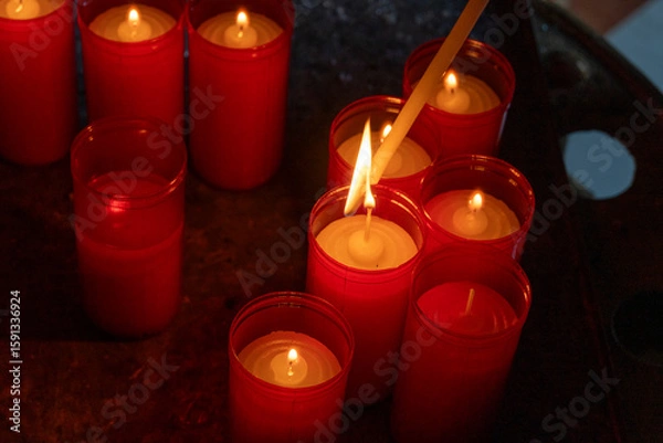 Fototapeta red candles being lit as an offering, religious concept