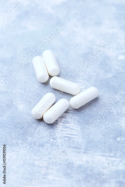 Fototapeta Creatine capsules on bright wooden background. Soft focus. Close up. Copy space.