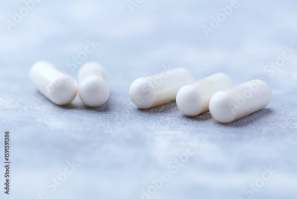 Fototapeta Creatine capsules on bright wooden background. Soft focus. Close up. Copy space.