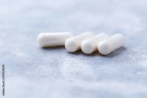 Fototapeta Creatine capsules on bright wooden background. Soft focus. Close up. Copy space.