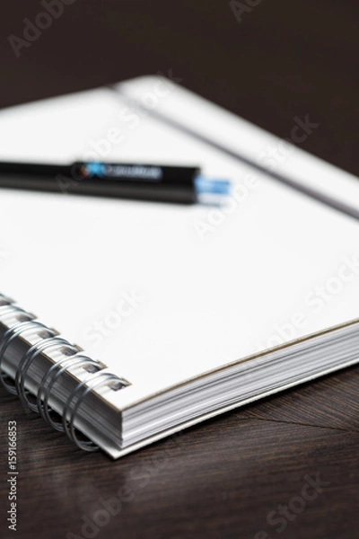 Fototapeta White notebook with a pen on an office close up