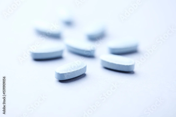Fototapeta Multivitamin tablets on bright paper background. Close up. Copy space	