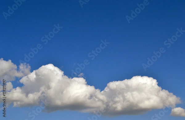 Fototapeta Fluffy clouds in a clear sky