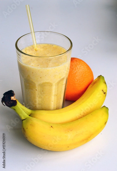 Fototapeta A composition of bananas and orange and a glass with smoothies
