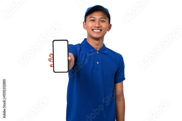 Fototapeta Asian delivery man wearing blue uniform showing smartphone with blank screen