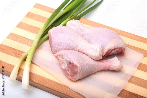 Obraz raw chicken legs with spices on a wooden board. Ready for cooking.