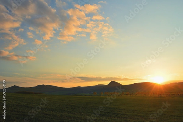 Fototapeta Colorful Sunset over Silhouetted Hill Ridge with Spectacular Clouds in the Sky