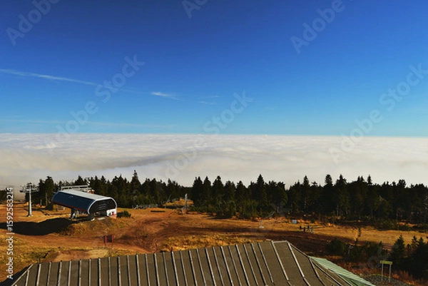 Fototapeta Clouds Engulf Valley While Hilltop Architecture Catches the Light