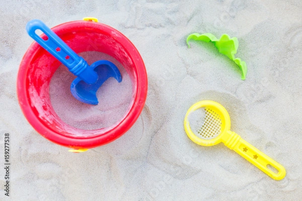 Obraz Plastic bucket, sifter and a small shovel in the sand; view from above