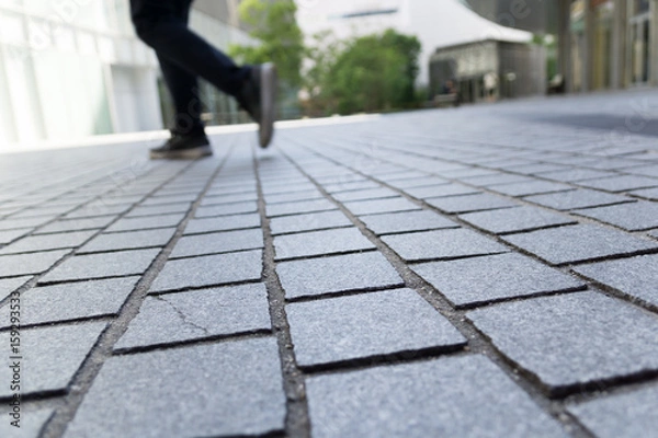Obraz 石畳の歩道を歩くビジネス街の足元イメージ｜通勤・通学・前進を表すローアングル写真