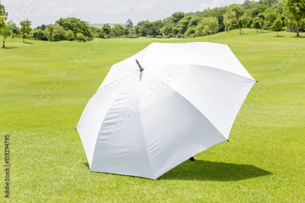 Fototapeta Miejsce na biały parasol słoneczny na polu golfowym z zieloną trawą do ochrony przed słońcem.