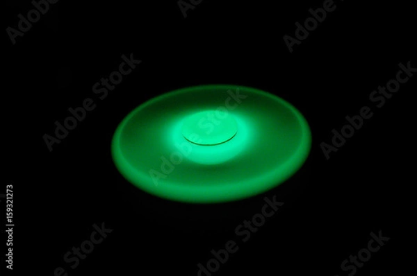 Fototapeta Glowing in the dark fidget spinner, rotating