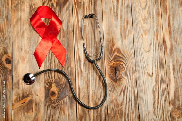 Obraz Red ribbon on hand support for World aids day and HIV virus awareness concept
