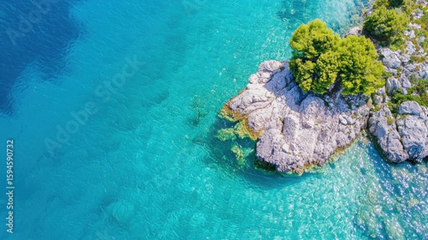 Obraz Aerial view of rocky coastline with clear turquoise water and lush green trees, creating serene and tranquil atmosphere