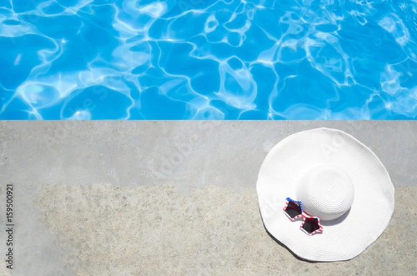 Fototapeta Summer background with hat and sunglasses near the pool