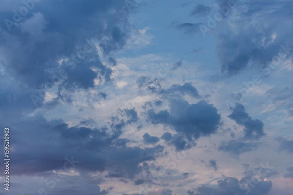 Fototapeta Ragged blue clouds in the evening sky. Dark clouds cover the clear sky. View up. View from above. Beauty of nature. Heavenly landscape.
