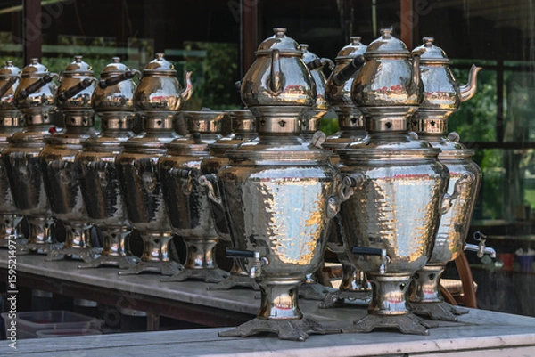 Fototapeta Shiny metal samovars and teapots for brewing tea on top. The interior of a cafe in Turkey with a view of tea brewing appliances. Tea ceremony and national tea-making traditions.