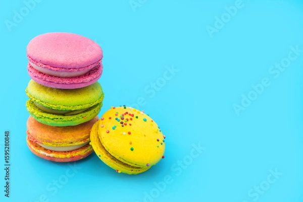 Obraz A few brightly colored stacked macarons on blue background.