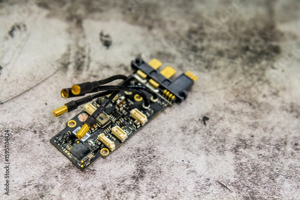 Fototapeta Detailed view of a small circuit board with wires and components on a textured background