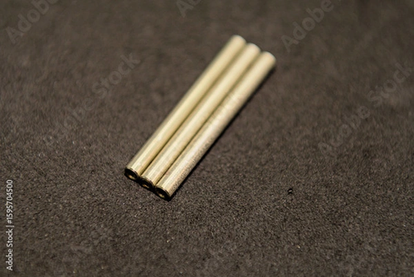 Fototapeta Closeup of three closely arranged standoff spacer on a dark surface