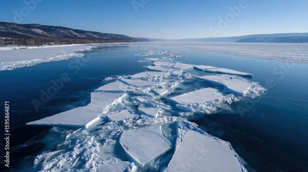 Fototapeta Icebergs float on serene blue lake surrounded by mountains under clear sky, showcasing beauty of nature texture and tranquility