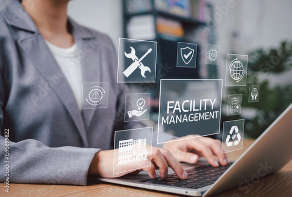 Fototapeta Facility Management Concept. Professional works on laptop with digital icons representing facility management, security, maintenance tools, AI, sustainability, safety, and smart building operations.