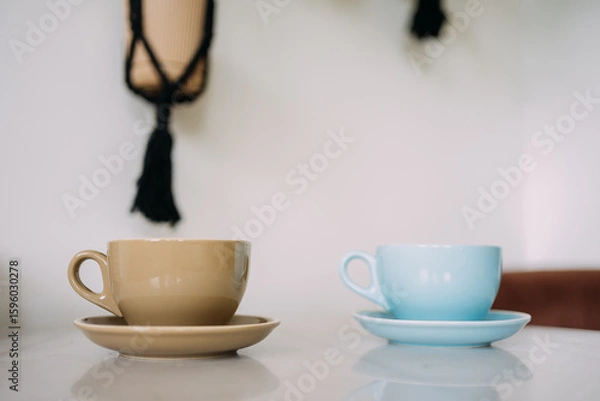 Obraz Two cappuccino cups on white table surface