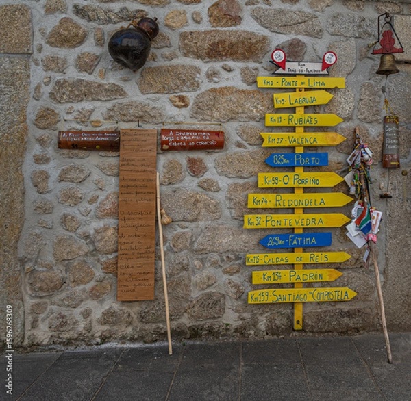 Fototapeta Wooden plaques and signposts showing distances from Viana do Castelo to various destinations along the Caminho de Santiago.