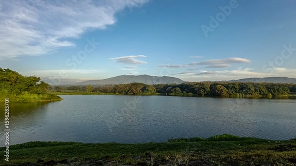 Fototapeta A truly beautiful view in the morning. The sky was so clear and blue. The reservoir was set against a backdrop of hills and mountains.