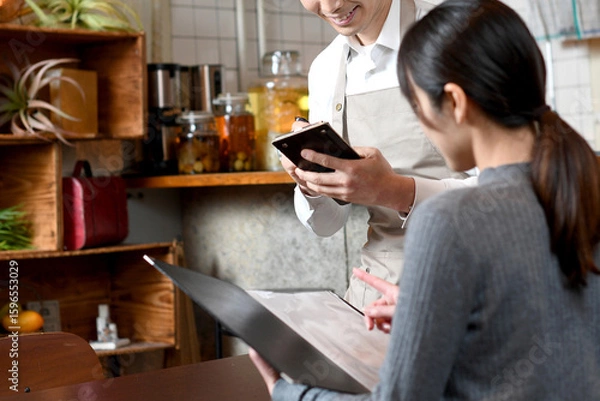 Obraz 飲食店で接客するアジア人の男性の店員