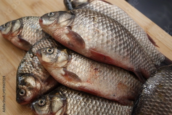 Fototapeta A bunch of fresh crucian carp in the cook's kitchen.