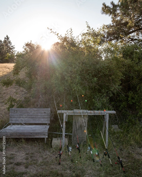 Obraz Wooden bench and a collection of fishing poles