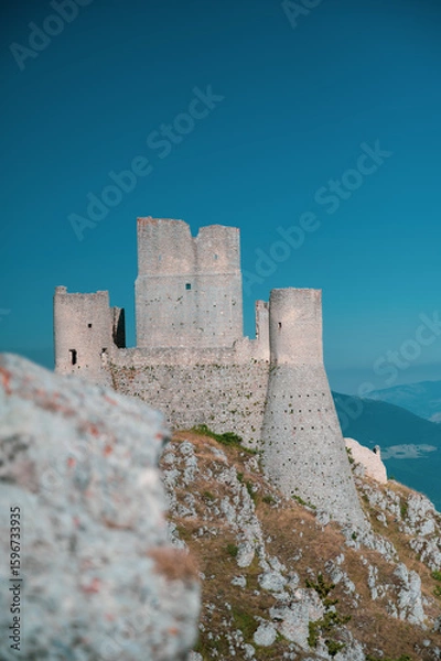 Fototapeta Italy, July 5, 2025: Ruins of Rocca Calascio Castle, an Italian tourist destination and landmark in the Gran Sasso National Park, L'Aquila, Abruzzo. Clear blue skies at sunset.