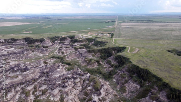 Fototapeta Drumheller Alberta Canada Aerial View of Rugged Badlands Terrain With Eroded Hills in Horseshoe Canyon and Vegetation distinct stratified layers and scattered patches of vegetation under cloudy skies