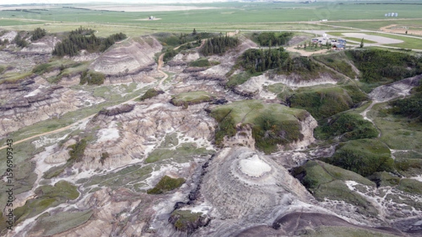 Fototapeta Drumheller Alberta Canada Aerial View of Rugged Badlands Terrain With Eroded Hills in Horseshoe Canyon and Vegetation distinct stratified layers and scattered patches of vegetation under cloudy skies