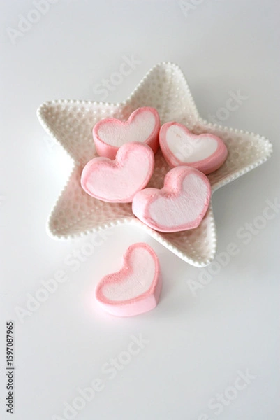 Fototapeta Heart-shaped marshmallow on a white plate. White background. There is free space for text. Vertical photo.