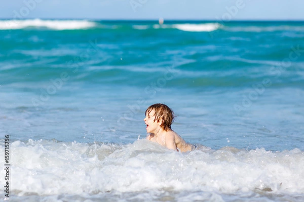 Obraz little blond kid boy having fun on ocean beach in Florida