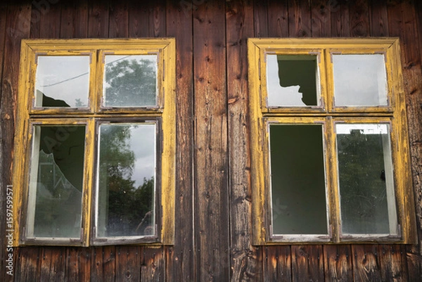 Obraz Two windows with yellow frames and broken glass