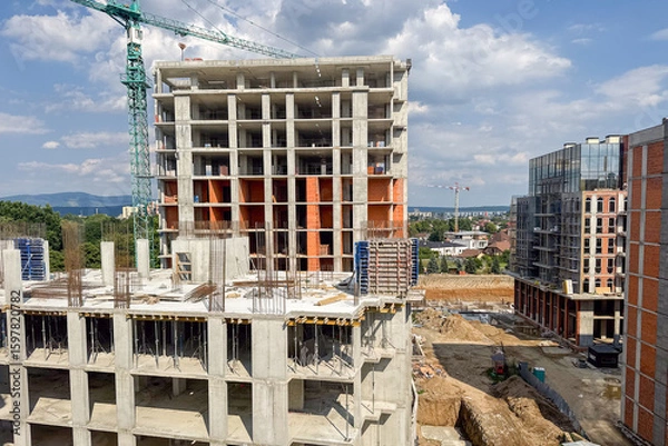 Fototapeta A multi-level concrete building is under construction with visible steel reinforcements
