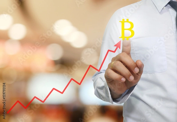 Fototapeta hand of businessman touche to symbol of bitcoin in business graph.