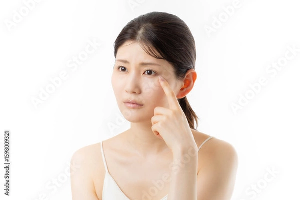 Fototapeta 肌の悩みを気にする若い女性の表情（白背景）