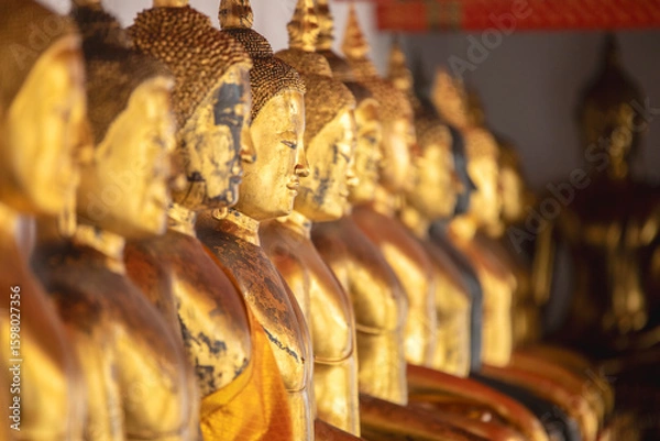 Fototapeta Row of golden Buddhas in the cloister of one of the Buddhist temples of Wat Phra Chetuphon - Wat Pho in Bangkok, Thailand.