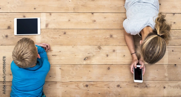 Fototapeta boy and girl using mobile technology header image
