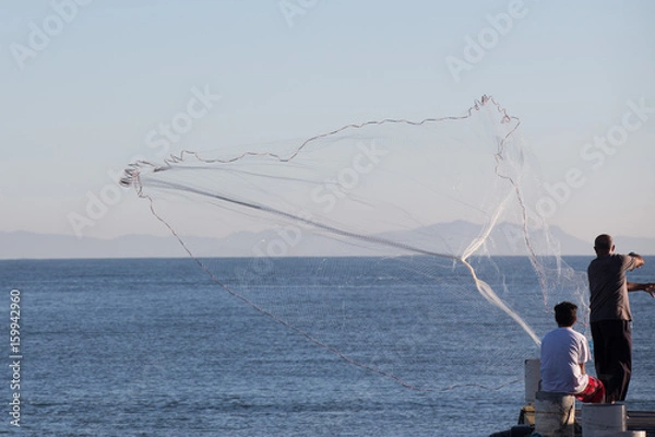 Obraz A fisherman using a fishing net