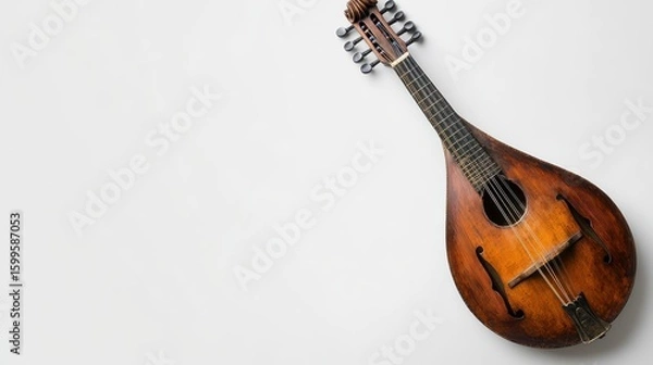 Fototapeta A mandolin with metal strings, space for text on the right side, against a clean white surface