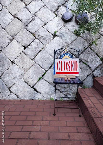 Obraz "CLOSED" sign board on a chair at an Italian restaurant