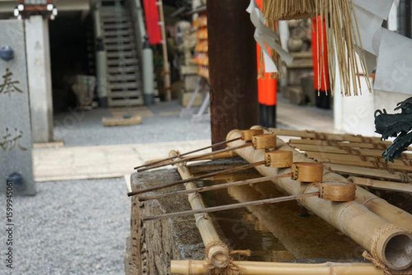 Obraz Tsukubai water basin with ladle, called a chozuya or temizuya, at the entrance of a Shinto shrine where visitors cleanse themselves by washing hands and mouth