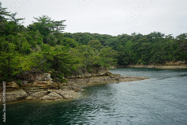 Obraz Nearby rocky coast of an island on the Japanese coast in the Saikai National Park's Kujukushima Islands, also called the 99 Islands, near Sasebo, Japan, as seen from the water